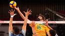 Pevoli Brasil, Lucas Saatkamp melakukan spike ke arah pemain Argentina pada babak penyisihan grup B bola voli putra Olimpiade Tokyo 2020 di Ariake Arena pada 26 Juli 2021. Lucas Saatkamp menggunakan masker saat berlaga demi melindungi dirinya dan keluarganya dari Covid-19. (AP Photo/Frank Augstein)