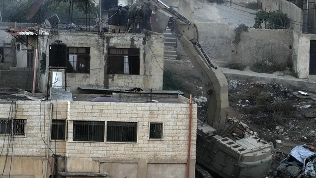 Potret pasukan Israel diabadikan oleh wartawan saat menjatuhkan jasad warga Palestina selama penyerbuan mereka ke Kota Qabatiya di Tepi Barat yang diduduki pada Kamis (19/9/2024).