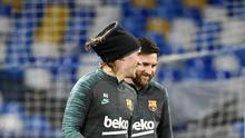 Penyerang Barcelona, Lionel Messi (kanan) berbincang dengan Antoine Griezmann saat menghadiri sesi pelatihan di stadion San Paolo di Naples, Italia (24/2/2020). Barcelona akan bertanding melawan Napoli pada leg pertama babak 16 besar Liga Champions. (AFP/Filippo Monteforte)