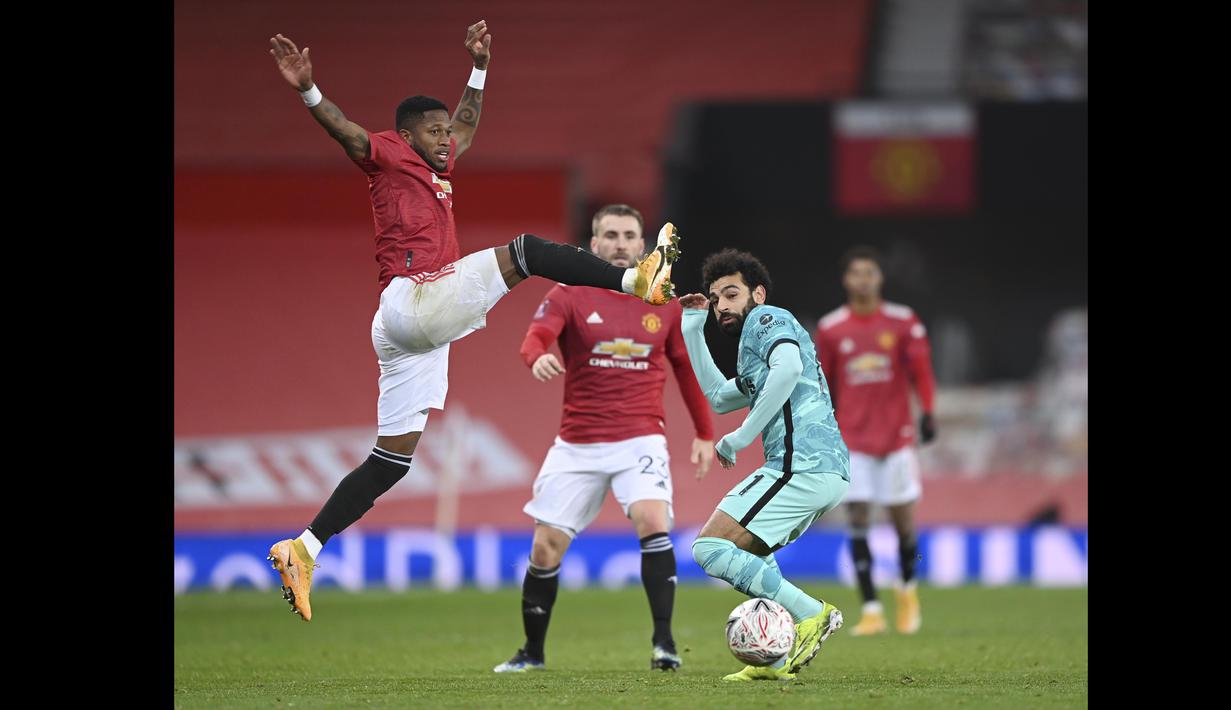 Pemain Manchester United, Fred (kiri) berusaha menghadang laju pemain Liverpool, Mohamed Salah pada laga babak keempat FA Cup 2020-21 di Old Trafford, Senin (25/01/2021). (Foto: AP/Pool/Laurence Griffiths)