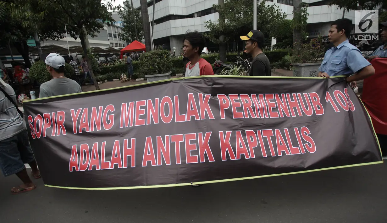 Massa membawa spanduk dalam aksi mendukung Permenhub Nomor 108 Tahun 2017 di depan Kementerian Perhubungan, Jakarta, Kamis (1/2). Mereka menyuarakan dukungan atas diterapkannya Permenhub terkait taksi online ini. (Liputan6.com/Arya Manggala)