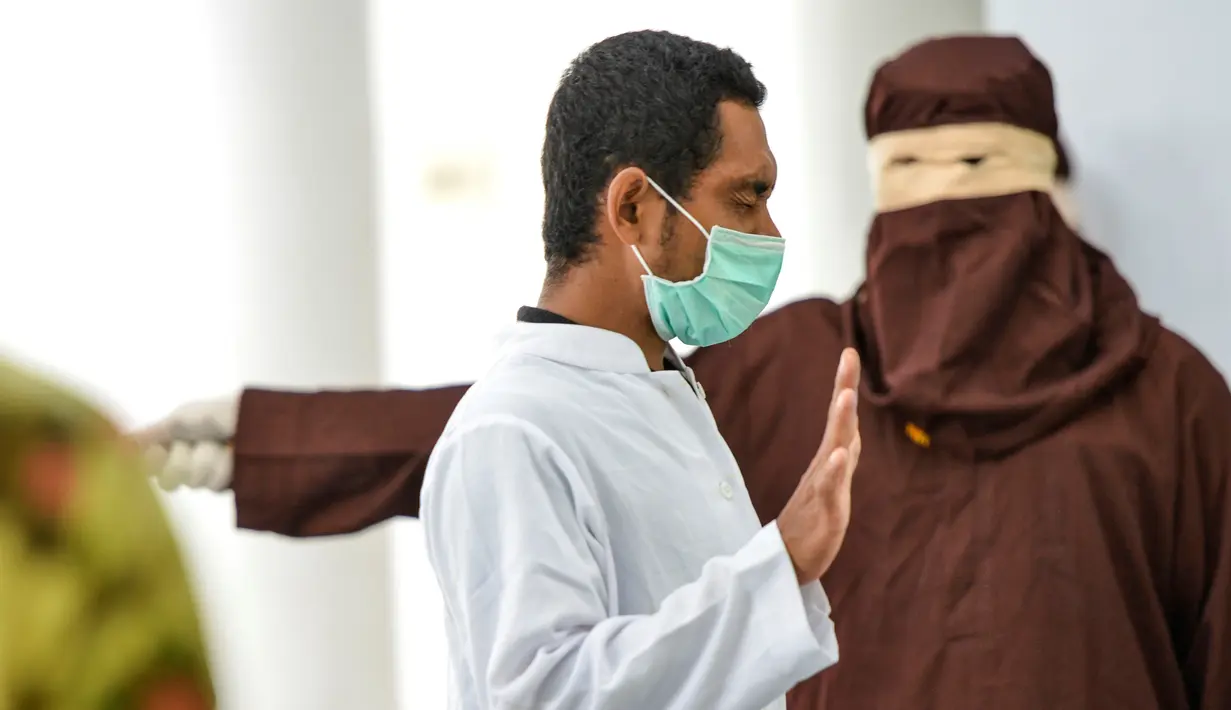 Seorang pria saat dihukum cambuk dengan tongkat rotan oleh anggota polisi Syariah di sebuah gedung umum di Banda Aceh (24/9/2020). Pria tersebut dihukum akibat melakukan aktivitas seksual dengan anak di bawah umur. (AFP/Chaideer Mahyuddin)