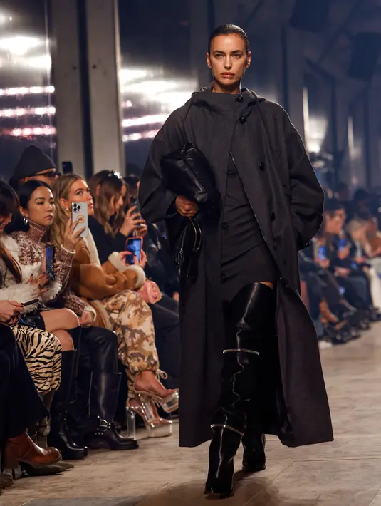 <p>Model Rusia Irina Shayk mempersembahkan kreasi dari koleksi Isabel Marant Womenswear Fall-Winter 2023-2024 pada Paris Fashion Week di Paris, Prancis, 2 Maret 2023. Model berusia 37 tahun ini menutupi sosoknya dengan mantel panjang berkerudung abu-abu arang yang dipadukan dengan sepasang sepatu bot hitam setinggi paha. (Vianney Le Caer/Invision/AP)</p>