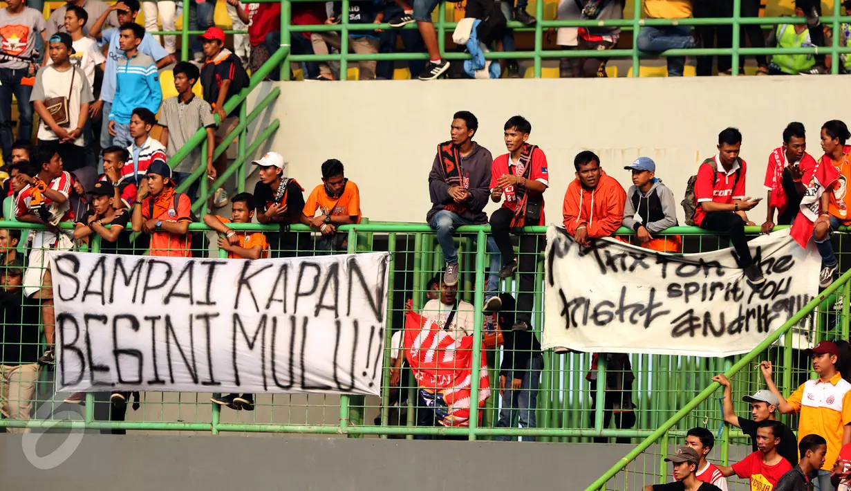 Suporter duduk di atas spanduk protes usai menyaksikan laga Persija melawan Mitra Kukar pada lanjutan Liga 1 Indonesia di Stadion Patriot Candrabhaga, Bekasi, Minggu (14/5). Laga kedua tim berakhir imbang 1-1. (Liputan6.com/Helmi Fithriansyah)