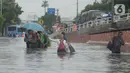 Warga RW 04 Kelurahan Jelambar melintasi banjir di Jakarta, Rabu (1/1/2020). Hujan yang turun saat pergantian tahun baru 2019-2020 menyebabkan sejumlah titik di kawasan Grogol terendam banjir. (merdeka.com/Imam Buhori)
