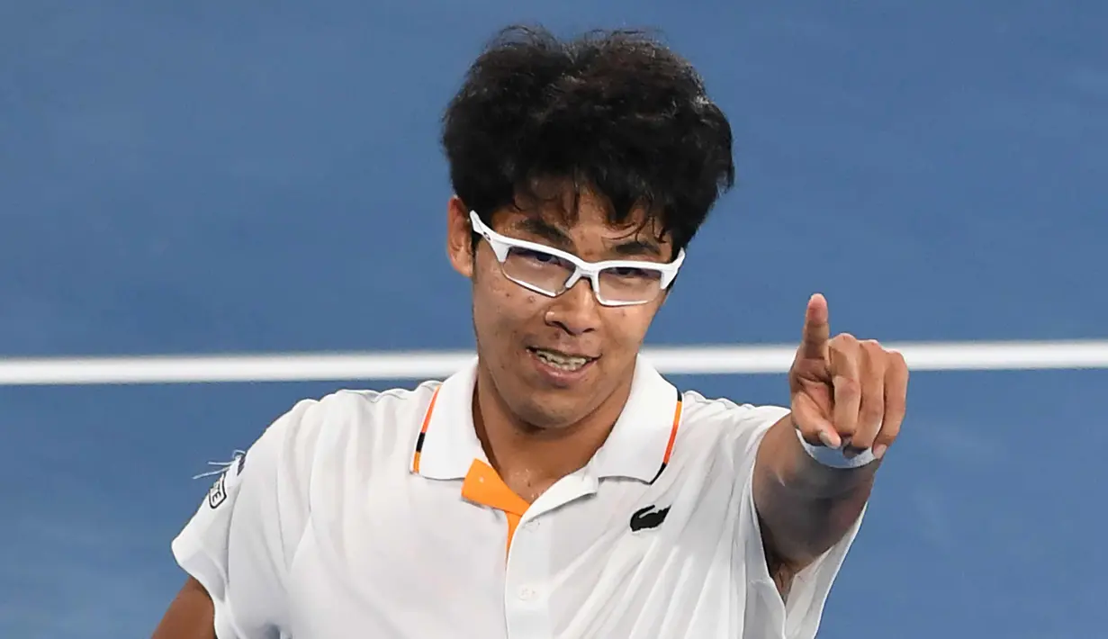 Petenis Korea Selatan Chung Hyeon melakukan selebrasi usai mengalahkan petenis Serbia, Novak Djokovic pada putaran keempat kejuaraan tenis Australia Terbuka di Melbourne (22/1). Chung Hyeon menang 6-7(4), 5-7, 6-7(3). (AFP Photo/Paul Crock)