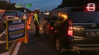 Petugas dari Polres Bogor memasang rambu penutupan jalan di pintu keluar Tol Gadog, Bogor, Sabtu (31/12/2022). Penutupan jalan jalur Puncak Bogor untuk gelaran Car Free Night dimulai sejak pukul 18.00 WIBdan dibuka kembali esok pagi pukul 06.00 WIB. (merdeka.com/Arie Basuki)