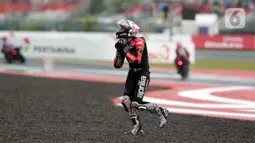 Pembalap Aprilia Racing, Aleix Espargaro berlari ke arah tribun penonton usai balapan MotoGP seri Pertamina Mandalika International Street Sirkuit, NTB, Minggu (20/3/2022). Aleix Espargaro menepati janjinya setelah meraih sejuta pengikut akun instagramnya. (Liputan6.com/Helmi Fithriansyah)