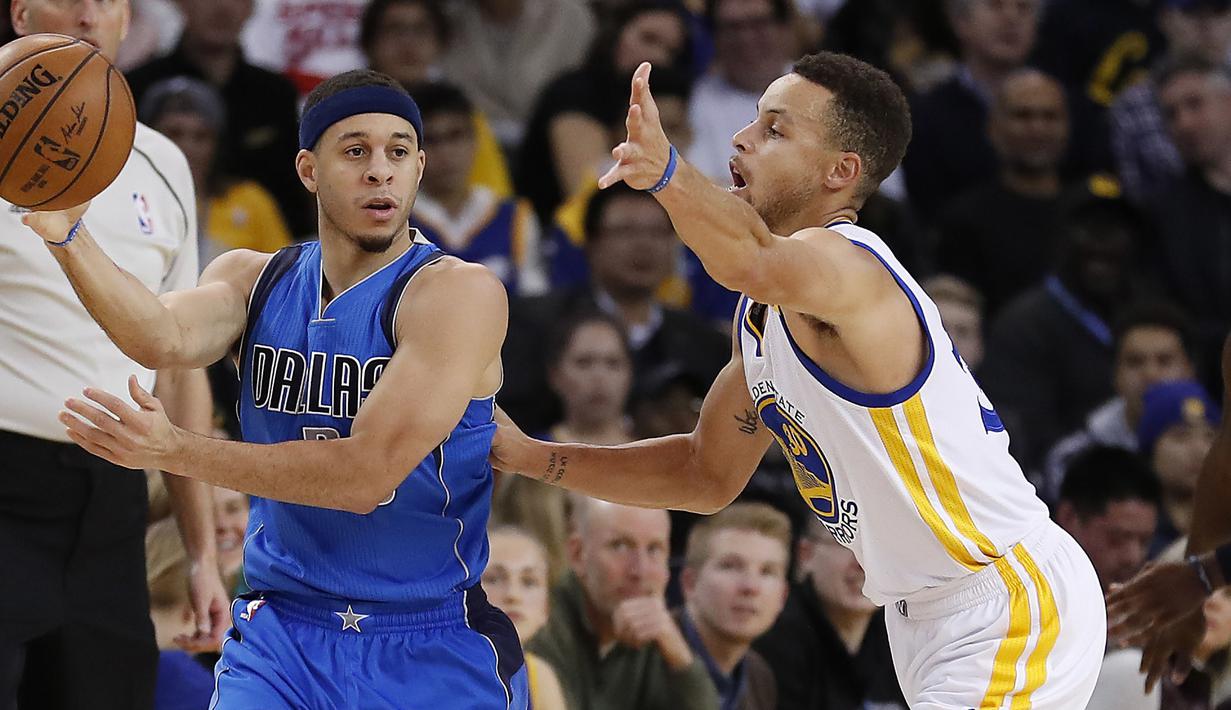 Pemain Dallas Mavericks, Seth Curry (kiri) mencoba melewati hadangan pemain Warriors, Stephen Curry (kanan) pada laga NBA basketball game  di Oakland, California, (30/12/2016). Warriors menang 108-99. (AP/Tony Avelar)