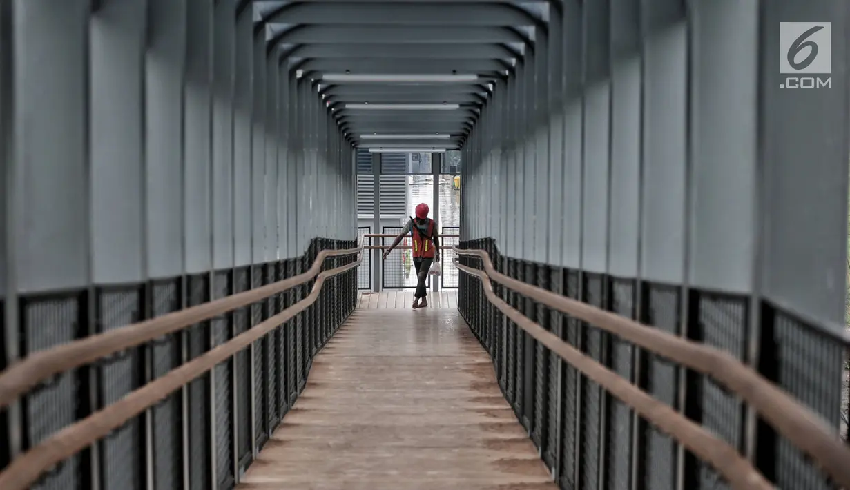 Pekerja melintas di jembatan penyeberangan orang (JPO) Bundaran Senayan, Jakarta, Senin (21/1). Fasilitas lift bagi difabel akan dilengkapi pada April mendatang. (Liputan6.com/Faizal Fanani)