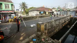 Pekerja menyelesaikan proyek revitalisasi Jembatan Cibubur, Jakarta, Selasa (2/8/2022). Revitalisasi dilakukan untuk mengantisipasi risiko banjir akibat rendahnya muka jembatan serta risiko kecelakaan akibat tidak adanya trotoar. (Liputan6.com/Faizal Fanani)