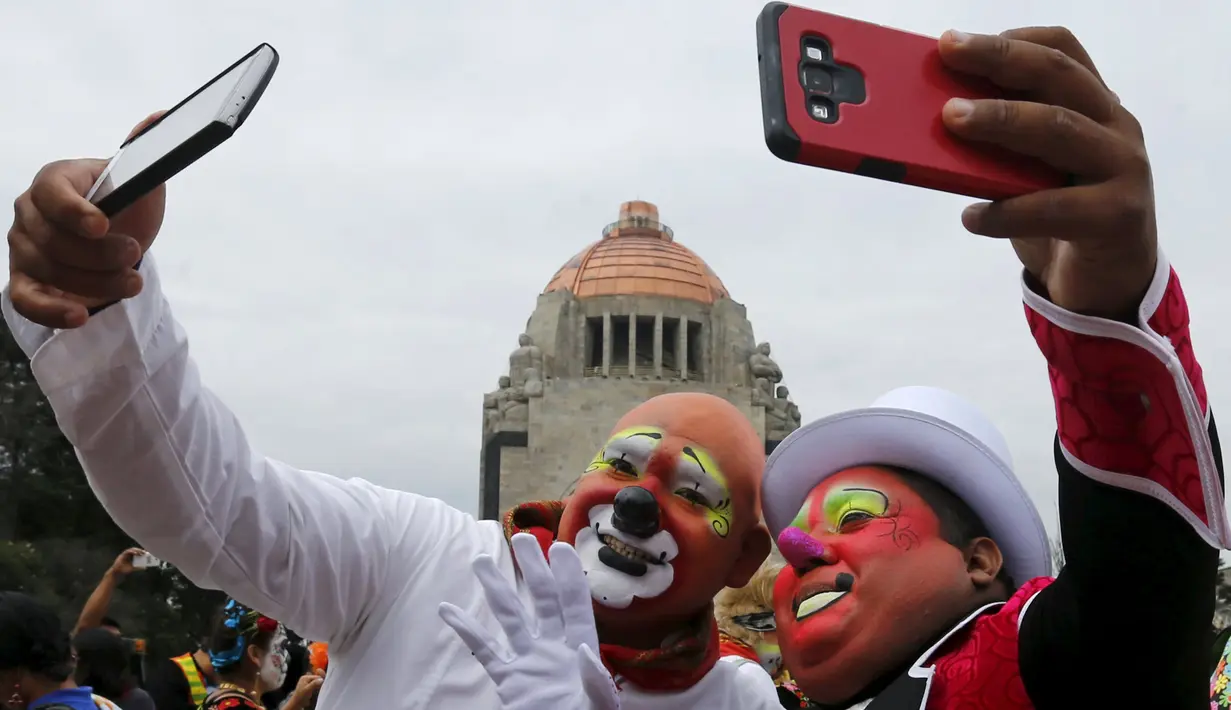 Dua orang badut berselfie saat menghadiri Konvensi Badut Internasional di depan Monumen Revolusi, Meksiko, Rabu (21/10). Meksiko menjadi tuan rumah Konvensi Badut Internasional ke-17 yang diselenggarakan pada 19-22 Oktober. (REUTERS/Henry Romero)
