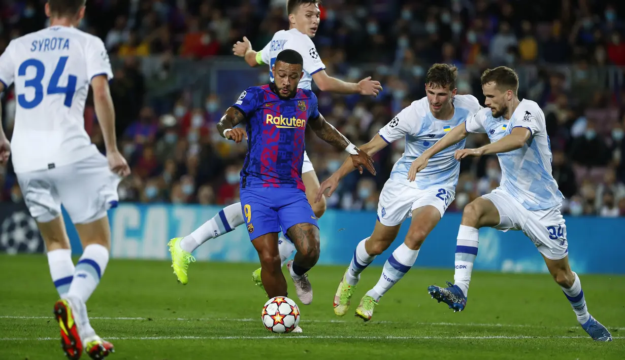 Penyerang Barcelona, Memphis Depay (tengah) membawa bola dari kawalan para pemain Dynamo Kyiv pada pertandingan lanjutan Grup E Liga Champions di di stadion Camp Nou di Barcelona, Spanyol, Rabu (20/10/2021). Barcelona menang tipis atas Dynamo Kyiv dengan skor 1-0. (AP Photo/Joan Monfort)