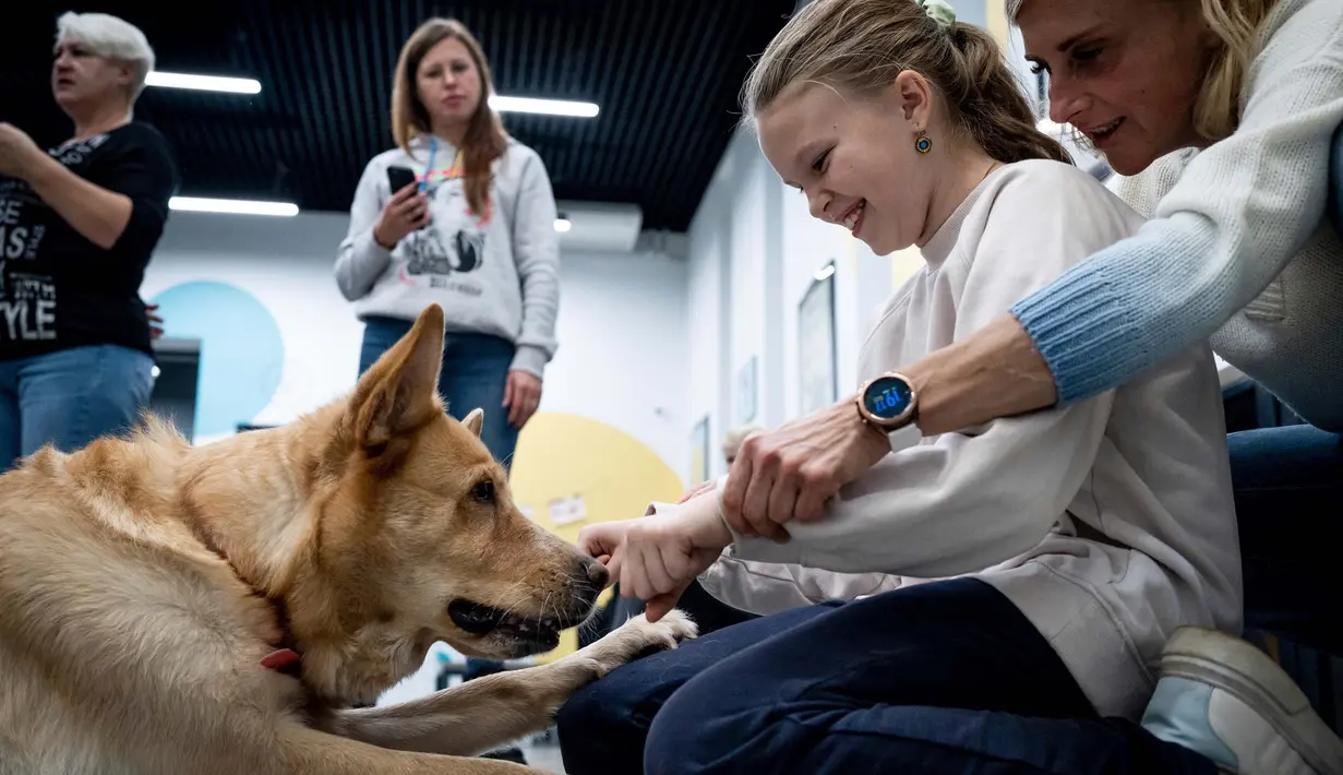 Di lokasi ini, mereka dapat mengatasi trauma dengan bantuan sekaligus bermain dengan dua ekor anjing, Chelsea dan Nike. (AP Photo/Roman Hrytsyna)