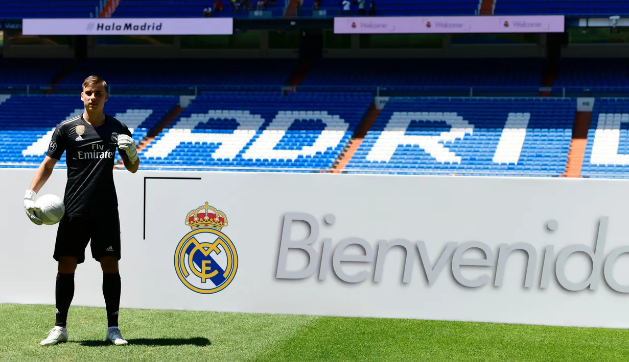 Kiper baru Real Madrid, Andriy Lunin berpose di lapangan saat presentasi di Stadion Santiago Bernabeu, Madrid, Spanyol, Senin (23/7). Kiper berusia 19 tahun ini didapatkan El Real dari klub Liga Ukraina, FC Zorya Luhansk. (JAVIER SORIANO/AFP)