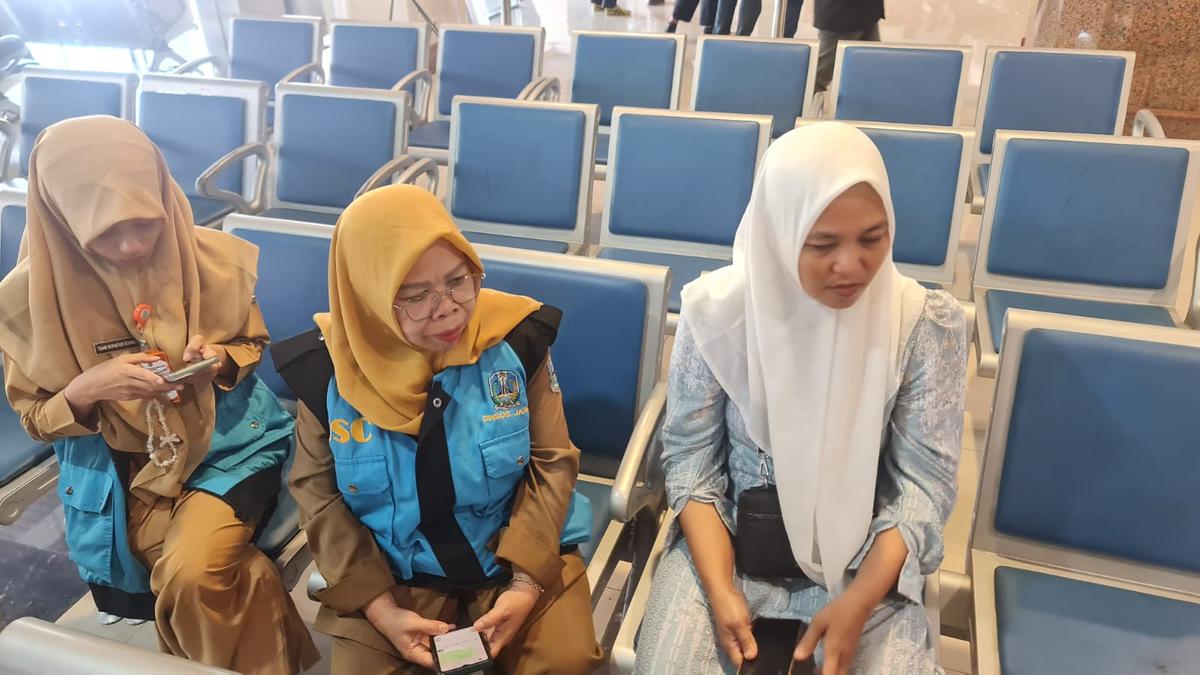 Umi istri salah satu penumpang KM Virgo menunjukkan foto sang suami. (merdeka.com/Erwin yohanes).