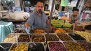 Seorang pedagang menjual zaitun dan acar sayuran di pasar populer di Baghdad, Irak (24/5/2019). Umat Muslim di seluruh dunia tengah melaksanakan puasa dimana mereka tidak makan, minum mulai dari matahari terbit hingga terbenam. (AFP Photo/Ahmad Al-Rubaye)