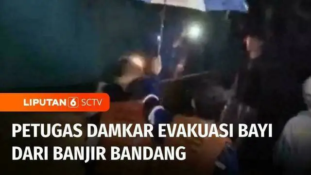 Bayi berusia 3 bulan dievakuasi petugas Damkar melewati banjir bandang yang masih merendam di Rajabasa, Bandar Lampung, Sabtu malam. Petugas menggendong bayi sambil berpegangan tali tambang, agar tidak terbawa arus banjir.