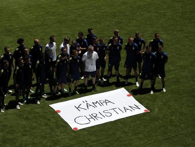 Tim Swedia berpose di sebelah tanda bertuliskan "Get Well Christian" untuk gelandang Denmark Christian Eriksen selama sesi latihan di stadion La Cartuja di Seville, Spanyol, Minggu (13/6/2021). Swedia akan bertanding melawan Spanyol pada Grup E Euro 2020. (Julio Munoz/Pool via AP)