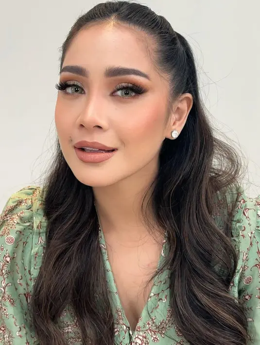 Complexion-nya terlihat matte flawless, contour wajah dibuat tegas, dan alis dibingkai rapi.
Kemudian riasan mata Nagita dibuat lebih glam, ditambah bulu mata palsu yang lentik dan tebal,  serta aplikasi overdrawn lips menggunakan lipstik warna nude. [@tasyafarasya]