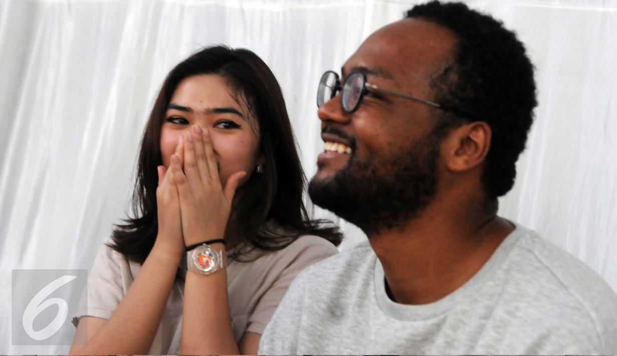 Isyana Sarasvati dan personel Dekat, Mohammed Kamga seusai latihan bersama Erwin Gutawa Orchestra di kawasan Cilandak, Jakarta, Minggu (21/8). Isyana dan Kamga akan duet pada malam puncak HUT SCTV ke-26. (Liputan6.com/Helmi Afandi)