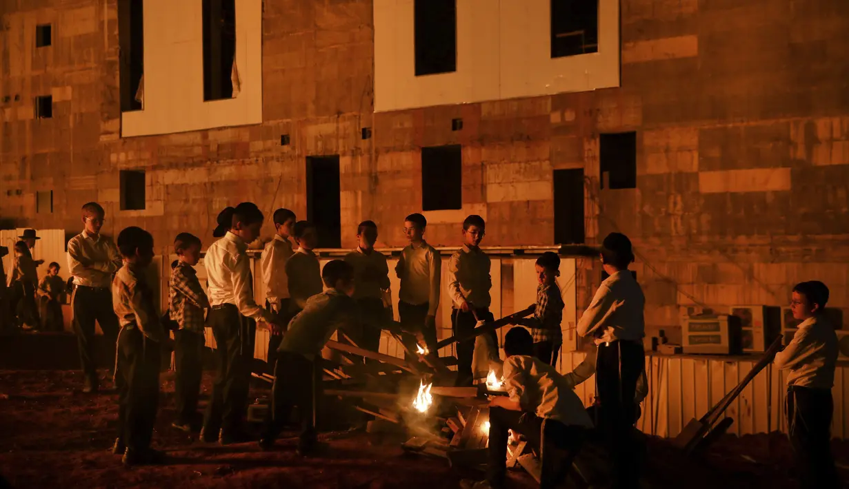 Ultra-Ortodoks Yahudi menyalakan api unggun selama hari libur Yahudi perayaan Lag Ba'Omer di Bnei Brak, Israel, Kamis (29/4/2021). Liburan Lag Ba'Omer, menandai berakhirnya wabah yang dikatakan telah membinasakan orang Yahudi selama zaman Romawi. (AP Photo/Sebastian Scheiner)