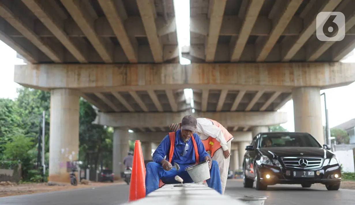 Pekerja menyelesaikan pembuatan separator atau pembatas jalan di Jalan Margasatwa, Andara, Jakarta Selatan, Kamis (21/11/2019). Separator itu dibuat guna memisahkan dua lajur sehingga meminimalisasi tingkat kecelakaan. (Liputan6.com/Immanuel Antonius)