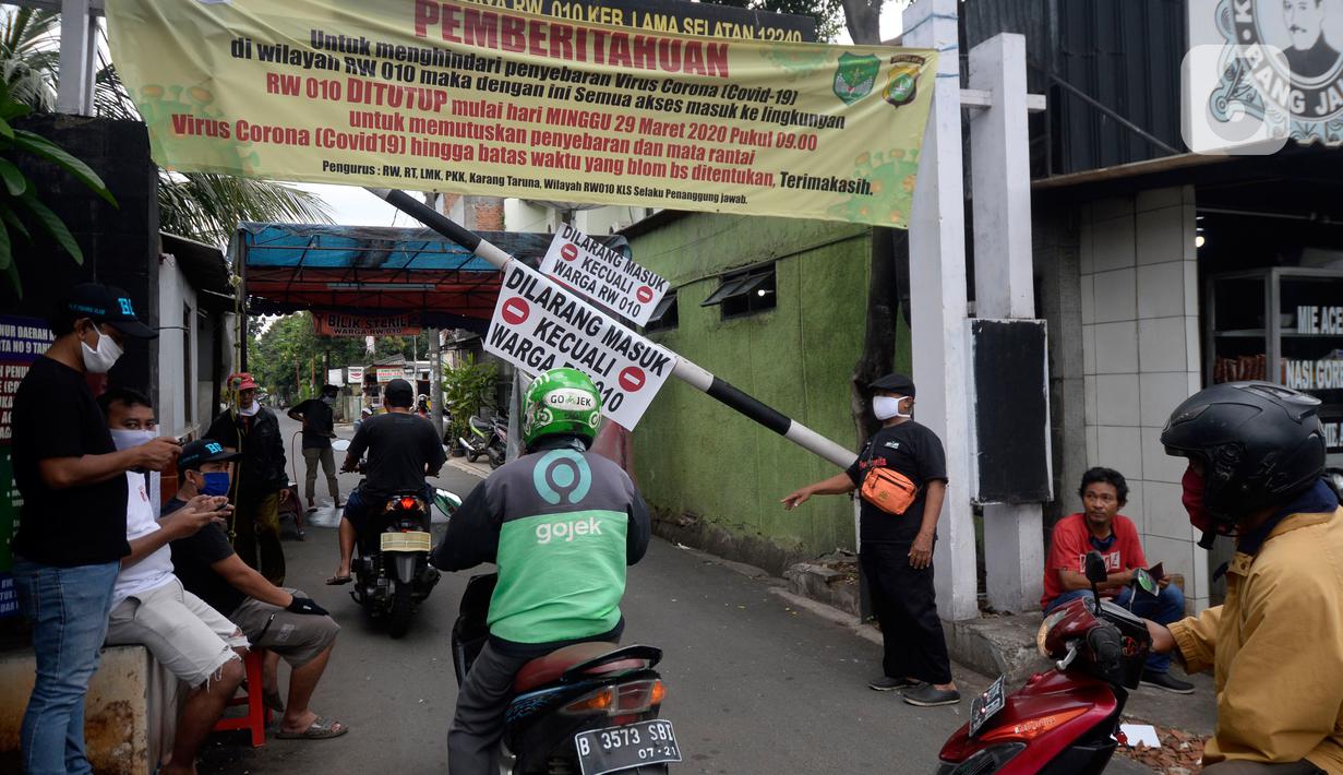 Sejumlah pemuda menjaga portal karantina wilayah menuju RW 10 di kawasan Tanah Kusir, Kelurahan Kebayoran Lama Selatan, Jakarta, Rabu (8/4/2020). Warga menerapkan akses satu pintu masuk pemukiman yang terdiri dari 12 RT tersebut untuk mencegah penyebaran corona COVID-19. (merdeka.com/Dwi Narwoko)