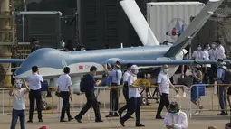 Pengunjung berjalan melewati drone CH-4 buatan China selama Pameran Penerbangan dan Antariksa Internasional China ke-13, juga dikenal sebagai Airshow China 2021 di Zhuhai di provinsi Guangdong, China (38/9/2021). (AP Photo/Ng Han Guan)