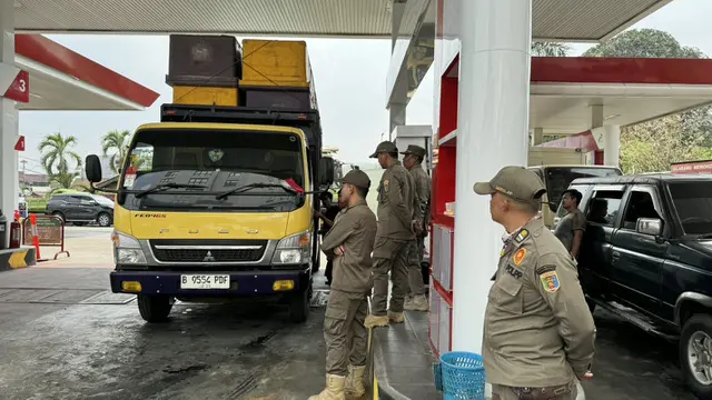 Personel Satpol PP Lampung saat membantu Pertamina memeriksa kesesuaian QR Code dengan STNK sebelum kendaraan masuk SPBU.
