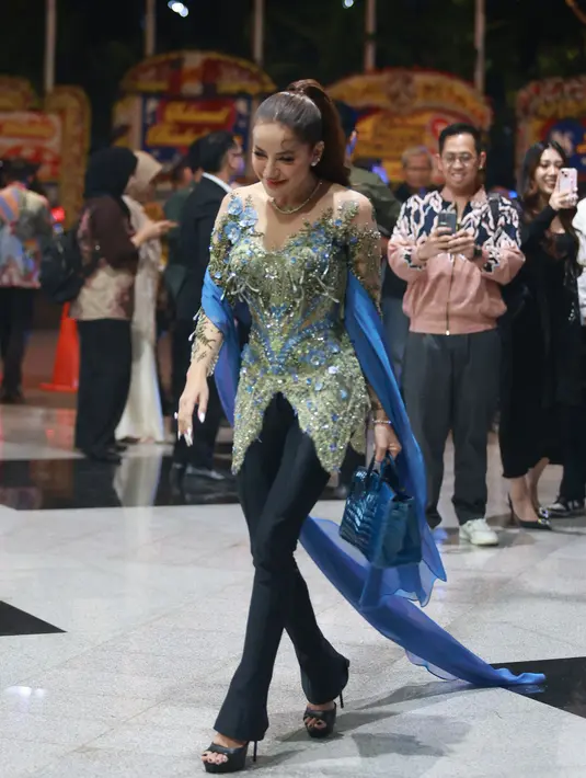 Olla Ramlan padukan kebaya hijau mint bersemat payet biru dengan celana panjang dan heels tinggi