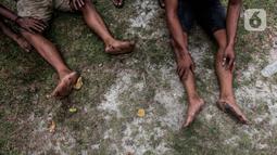 Peserta beristirahat disela lomba panjat pohon pinang di Pantai Festival Ancol, Jakarta, Rabu (17/8/2022). Sebanyak 45 pohon pinang siap dipanjat oleh pengunjung di Pantai Festival Ancol  untuk memeriahkan Hari Ulang Tahun (HUT) Ke-77 Republik Indonesia. (Liputan6.com/Faizal Fanani)