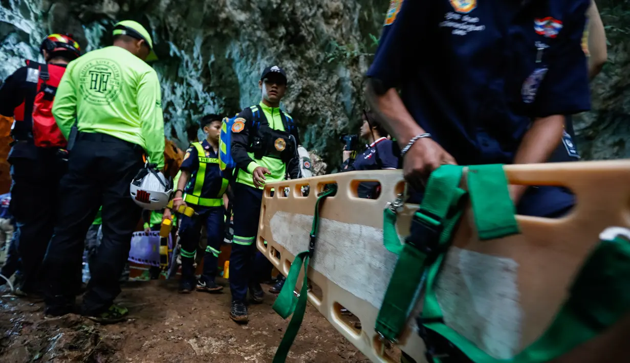 Tim penyalamat keluar dari gua saat mencari tim sepak bola remaja yang hilang di provinsi Chiang Rai, Thailand (26/6). Mereka terjebak saluran air sempit sejauh 15 meter. (AFP/Thai News Pix/Krit Phromsakla Na Sakolnakorn)