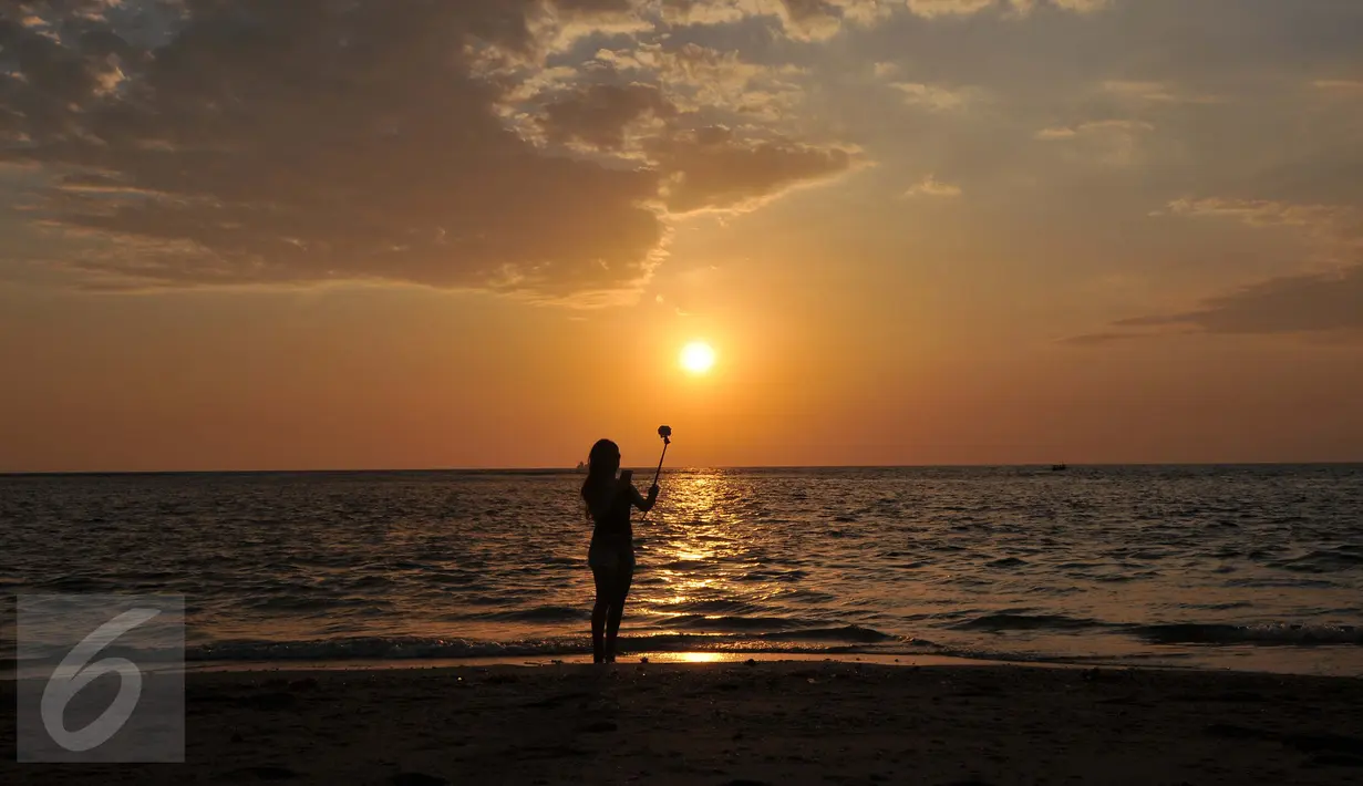 Wisatawan menikmati keindahan sunset di Pantai Sengigi, NTB (13/10/2015). Pulau Lombok terpilih sebagai pemenang dalam ajang internasional World’s Best Halal Travel Summit di Abu Dhabi, Uni Emirate Arab (UEA).(Liputan6.com/Gempur M Surya)
