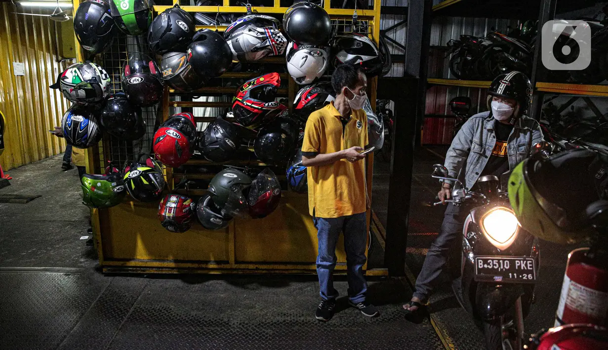 Pelanggan mengeluarkan motornya di Soul Parking, Kebon Kacang, Jakarta, Senin (24/1/2022).Tempat parkir vertikal tersebut menjadi salah satu solusi untuk penataan parkir khusus motor di wilayah Ibu Kota Jakarta. (Liputan6.com/Faizal Fanani)