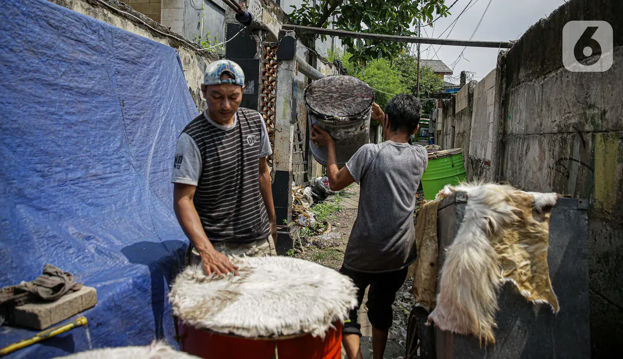 Pekerja menyelesaikan pembuatan bedug di jalan KH Mas Mansyur, Tanah Abang, Jakarta, Senin (10/6/2021). Menjelang Idul Fitri 1442 H, pedagang bedug di sepanjang jalan itu mulai ramai menjajakan dagangannya dari harga 40 ribu hingga Rp 2,5 juta. (Liputan6.com/Faizal Fanani)