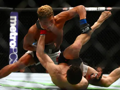 Pemain UFC  Teroto Ishihara melayangkan pukulannya kepada Julian Erosa pada pertandingan UFC 196 di MGM Grand Garden Arena, Las Vegas, (5/3). UFC adalah singkatan dari (ULTIMATE FIGHTING CHAMPIONSHIP). (Rebilas-USA TODAY Sports)