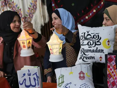 Para wanita menyiapkan dekorasi jelang bulan suci Ramadhan di Kota Gaza, Palestina, 31 Maret 2022. Ramadhan di Palestina akan dimulai pada akhir pekan ini. (MOHAMMED ABED/AFP)