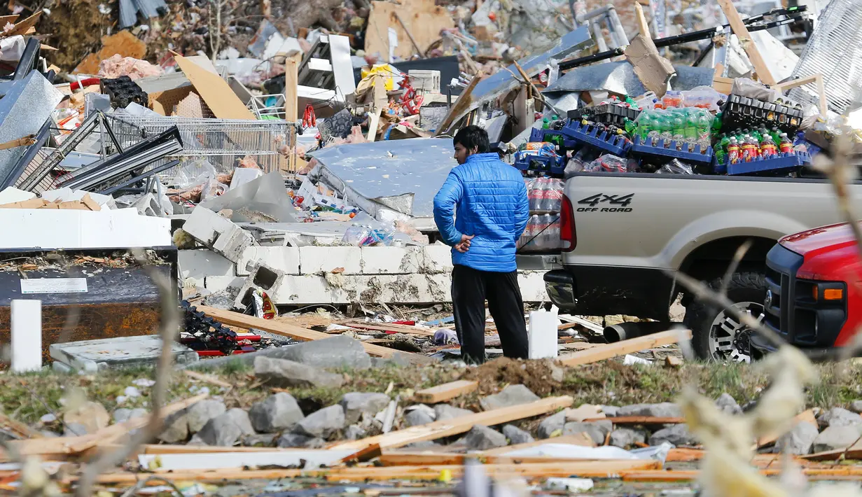 Seorang pria mencari barang-barang yang bisa dia selamatkan dari tokonya setelah tornado menerjang Cookeville, Tennessee, Amerika Serikat, Selasa (3/3/2020). Terjangan tornado menyebabkan kerusakan besar pada bangunan, jalan, jembatan, dan pusat bisnis. (AP Photo/Mark Humphrey)