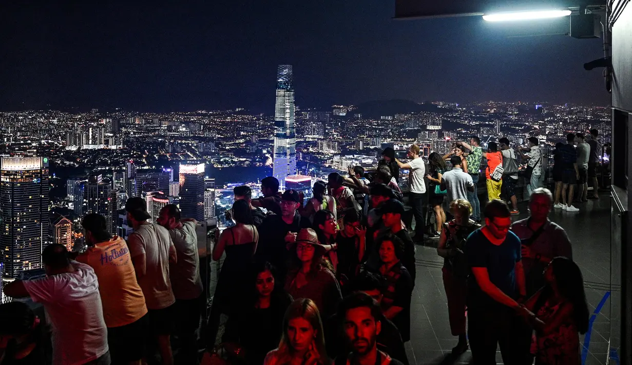 Gambar pada 14 Februari 2019, para turis menikmati dan mengambil gambar pemandangan cakrawala kota dari dek observasi Menara Kuala Lumpur di ibu kota Malaysia. Di sini pengunjung bisa mengamati segala penjuru kota Kuala Lumpur. (Mohd RASFAN / AFP)
