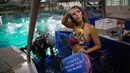 Mahasiswi biologi laut Isabela Cardoso berkostum putri duyung bersiap menyelam di Rio de Janeiro Aquarium, Brasil (14/1). Aksi Isabela tersebut untuk memprotes bahaya pencemaran laut dalam kehidupan laut di Rio de Janeiro. (AFP Photo/Mauro Pimentel)