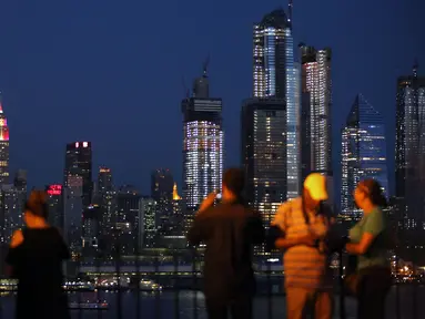 Gedung pencakar langit Empire State di New York memancarkan lampu warna bendera juara Piala Dunia 2018, Prancis, Minggu (15/7). Sebelumnya, pucak gedung terkenal di Amerika Serikat itu selalu menyalakan warna putih. (AFP PHOTO / KENA BETANCUR)