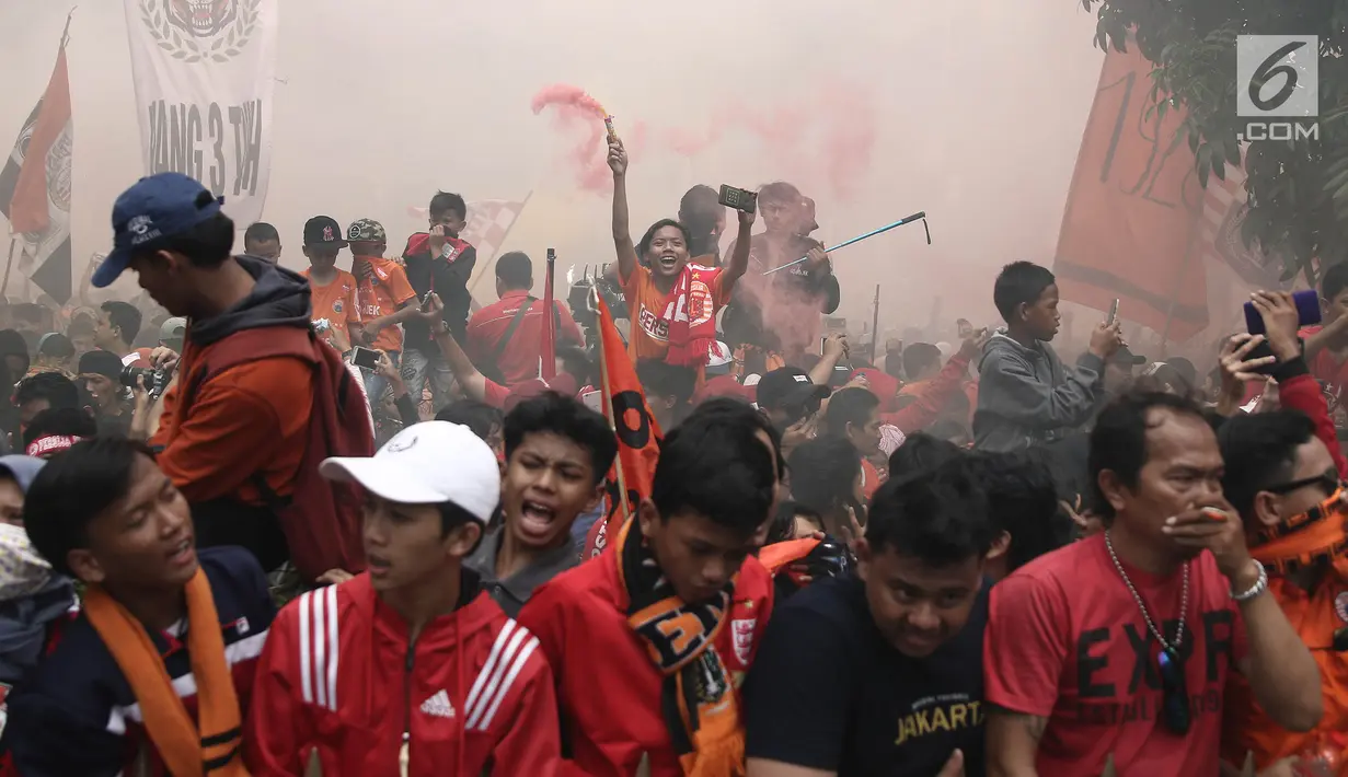Jakmania membakar bom asap warna-warni saat penyerahan piala Liga I di depan Balai Kota, Jakarta, Sabtu (15/12). Persija kembali meraih juara Liga Indonesia setelah 17 tahun. (Liputan6.com/Herman Zakharia)