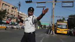 Polisi lalu lintas India, Ranjeet Singh arus kendaraan bermotor di persimpangan yang sibuk di Indore pada 18 November 2019. Singh yang memiliki kumis ala Freddie Mercury ini mengatur lalu lintas sambil menari juga bergerak menghindari bajaj dan truk yang melintas. (AP/Aijaz Rahi)