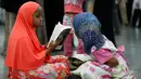 Seorang anak membaca Al Quran ketika menghadiri salat jenazah Muhammad Ali di Louisville, Kentucky, AS, Kamis (9/6). Suasana khusyuk terlihat selama prosesi penghormatan terakhir jelang pemakaman legenda tinju dunia, Muhammad Ali. (REUTERS/Lucy Nicholson)