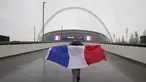 Seorang suporter Prancis membawa bendera Prancis saat menuju Stadion Wembley, London, jelang pertandingan persahabatan antara Inggris melawan Prancis, Selasa (17/11/2015). (AFP Photo/Justin Tallis)