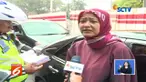 Perdebatan antara wanita pengendara mobil dengan plat nomor genap dengan Polantas di Simpang Pancoran, Jakarta Selatan, berlanjut hingga keluar kendaraan.