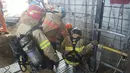 Petugas penyelamat saat akan turun ke lokasi robohnya konstruksi kereta bawah tanah di Namyangju, dekat Seoul, Korsel, Rabu (1/6). Dugaan sementara, insiden ini dipicu oleh ledakan tabung silinder oksigen di lokasi proyek. (NAMYANGJU FIRE STATION/AFP)