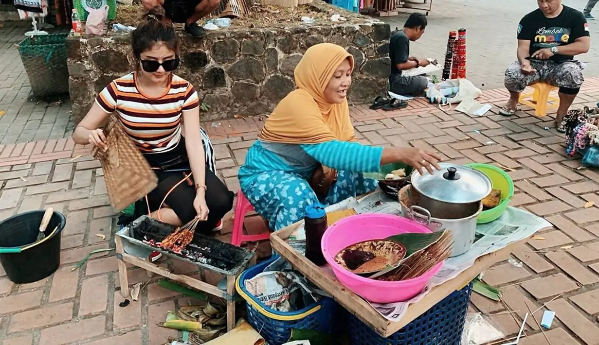 Saat liburan, Ghea Youbi sempat membeli sate. Sambil membantu ibunya membakar sate, potretnya yang diunggah dalam Instagramnya sejak lama ini sempat menjadi sorotan. Kabarnya dalam potretnya ini dirinya sedang liburan ke Lombok. (Liputan6.com/IG/@gheayoubi)