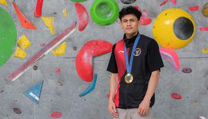 Atlet panjat tebing Indonesia, Veddriq Leonardo berfoto dengan medali emas Olimpiade Paris 2024 di markas FPTI, Hotel Santika Premier, Bekasi, Selasa (20/08/2024). (Bola.com/Bagaskara Lazuardi)